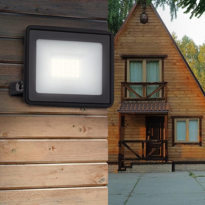 wooden two-story house with brown windows with a porch in the forest at sunset against the background of fir trees